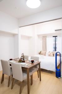 a dining room with a table and chairs and a bed at The Peak Tsutenkaku in Osaka