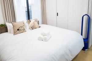 a white bed with two towels on top of it at The Peak Tsutenkaku in Osaka