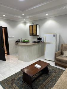 - une cuisine avec un comptoir, un réfrigérateur et une table dans l'établissement فندق درة المنابر الفندقية, à Médine