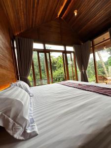 a large bed in a room with windows at Villa Pondok Utu, Ubud - Bali in Ubud