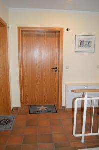 a room with a wooden door and a tile floor at Modernes Appartement mit Meerblick in Ahrenshoop