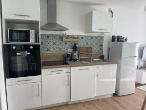a kitchen with white cabinets and a white refrigerator at Croix rouge in Châtellerault +17 photos