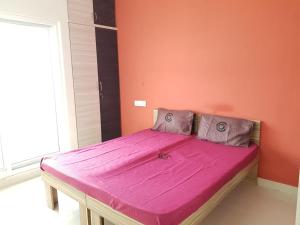 a bed in a room with an orange wall at C Suite- Cannes in Kammasandra
