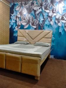 a bed in a room with a flower wall at New Faizan Hotel in Lahore