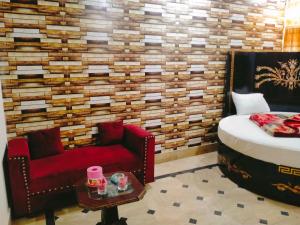 a bedroom with a bed and a couch and a chair at New Faizan Hotel in Lahore +1 photo