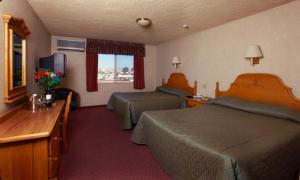 Cette chambre comprend deux lits et une télévision. dans l'établissement La Villa de Zaragoza, à Tijuana