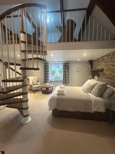 ein Schlafzimmer mit einem Bett und einer Wendeltreppe in der Unterkunft The old Manor House in Lifton + 56 Fotos