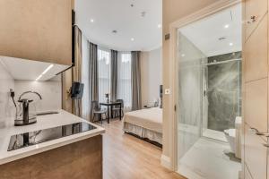 a hotel room with a bed and a bathroom at Cleveland Residences Chelsea in London