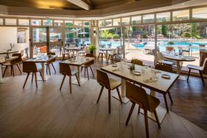 a restaurant with tables and chairs and a pool at Garrigae Domaine de l'Esterel - piscine & SPA Cinq Mondes in Saint-Raphaël