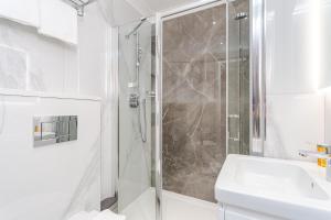 a bathroom with a shower and a sink at Cleveland Residences Chelsea in London