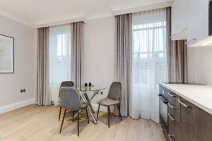a kitchen with a table and chairs in a room at Cleveland Residences Chelsea in London