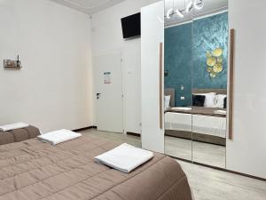 een slaapkamer met twee bedden en een spiegel bij Venetian Nexus in Mestre +27 foto's