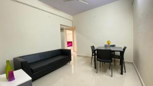 a living room with a black couch and a table at C Suites - Fallon in Bengaluru