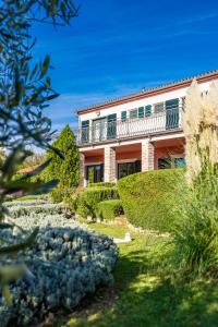 a house with a balcony on top of a yard at Villa Maddalena in Tinjan