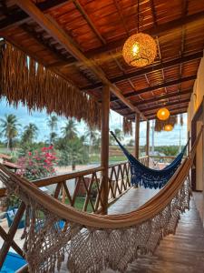 a hammock on a porch of a resort at Pousada Canaã Icaraizinho in Amontada