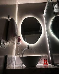 a bathroom with a sink with a round mirror at Damani Studios in Foz do Iguaçu +22 photos