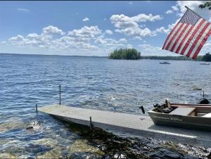 a boat on a dock with an american flag at DOCKSIDE RETREAT LIMIT 14 home in North Sebago