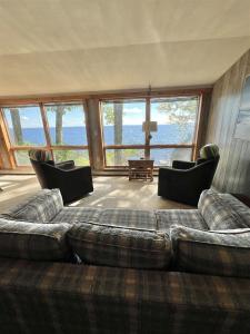 a living room with a large couch and chairs at DOCKSIDE RETREAT LIMIT 14 home in North Sebago +28 photos