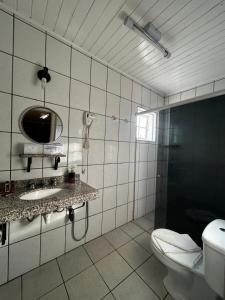 a bathroom with a toilet and a sink and a mirror at Pousada do Vento in Campos do Jordão +43 photos