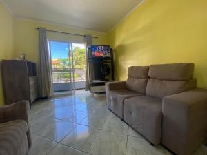 a living room with a couch and a television at B149 - Ampla casa no centro de Bombinhas - SC in Bombinhas