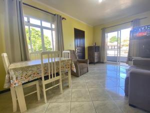 a dining room with a table and a couch at B149 - Ampla casa no centro de Bombinhas - SC in Bombinhas