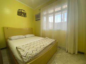 a small bedroom with a bed and a window at B149 - Ampla casa no centro de Bombinhas - SC in Bombinhas