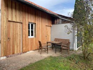 a patio with a table and two chairs next to a building at Ferienhaus mit Bar und Sauna in der Mitte Deutschlands in Duderstadt