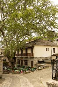 a building with a tree in front of it at Armoloi Traditional - Guest House in Konitsa +48 photos