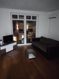 ヴルシャツにあるSandra apartmani 4のリビングルーム(黒いソファ、テレビ付)