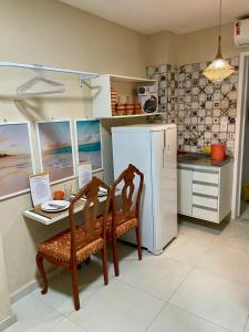 a kitchen with a table and chairs and a refrigerator at Pouso 46 - Studios no Santo Antônio Além do Carmo in Salvador
