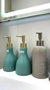 two soap dispensers sitting on a shelf in a bathroom at APARTAMENTO KELVIN - Edificio ON APARTMENTS in Lima