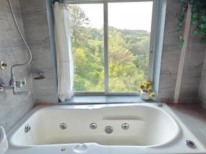 a white bath tub in a bathroom with a window at Tabletop Boutique Resort in Panchgani +51 photos