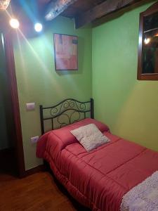 a bedroom with a red bed in a green wall at Casa Rural de Abuelo in Garafía +11 photos