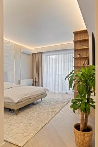 a bedroom with a bed and a potted plant at Studio Luxury Cortina North Residence Pipera in Voluntari