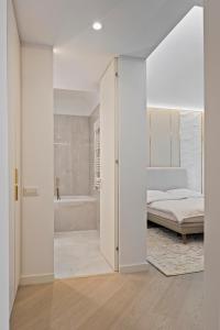 a white bedroom with a bed and a tub at Studio Luxury Cortina North Residence Pipera in Voluntari