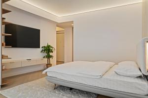 a bedroom with a bed and a flat screen tv at Studio Luxury Cortina North Residence Pipera in Voluntari