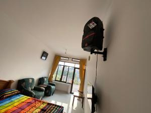 a bedroom with a bed and a television on a wall at Kamar no 5 in Sampal 2