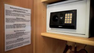 a microwave sitting on a shelf next to a menu at Hotel Am Weyerhof in Kerpen +15 photos