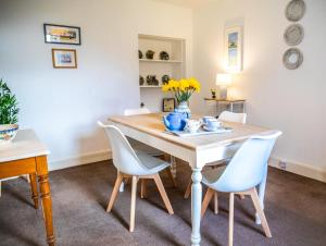 a dining room with a wooden table and chairs at Dalvey Mill Cottage in Forres