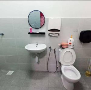 a bathroom with a sink and a toilet and a mirror at Homestay Raikan Cinta in Malacca