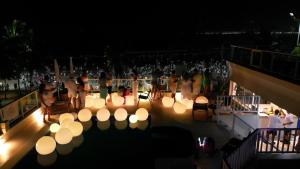 a group of people standing on a deck at night at The Falls Hotel in Guarujá +45 photos