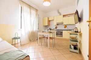 a kitchen with yellow cabinets and a table in a room at Borgo View - con posto auto privato incluso in Livorno