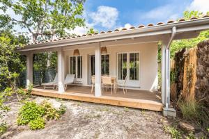 CassyにあるAppt Premium environnement boise Bassin d Arcachonのポーチ(テーブル、椅子付)が備わる家