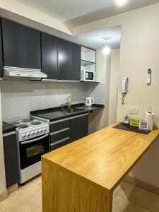 a kitchen with black cabinets and a wooden counter top at Cielo Norteño in San Salvador de Jujuy