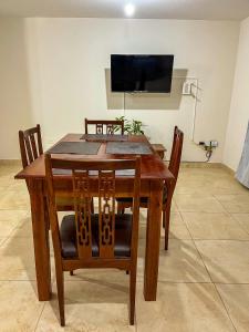 a wooden table with chairs and a television on a wall at Cielo Norteño in San Salvador de Jujuy