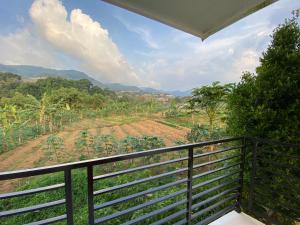 a balcony with a view of a field at Kamar no 5 in Sampal 2