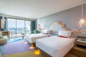 a hotel room with two beds and a balcony at W Algarve in Albufeira