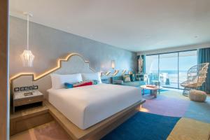 a bedroom with a large bed and a living room at W Algarve in Albufeira