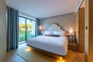 a bedroom with a large white bed and a large window at W Algarve in Albufeira