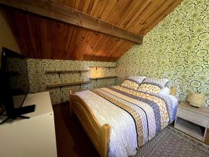 Un dormitorio con una cama y una pared de madera. en La Lézardière - Chalet spacieux près des pistes, en La Toussuire